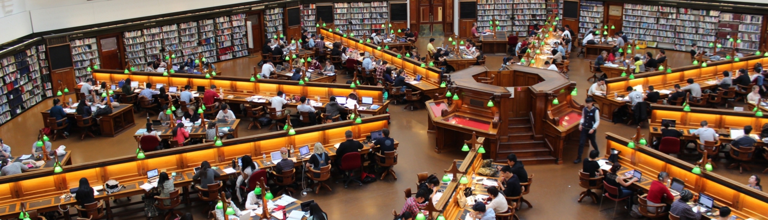 Birdseye view of library filled with people at desks reading