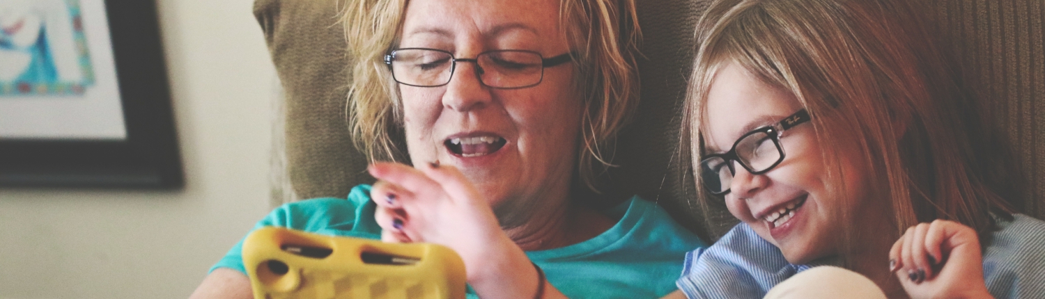 Parent and child using a tablet on the couch together