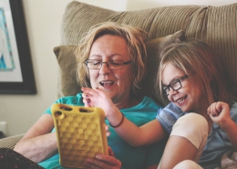 Parent and child using a tablet on the couch together