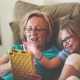 Parent and child using a tablet on the couch together