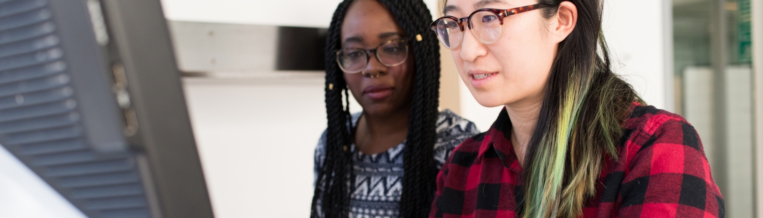 Two women working at a computer together