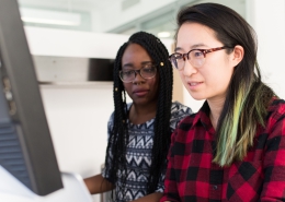 Two women working at a computer together