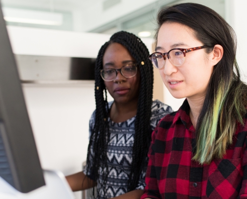 Two women working at a computer together
