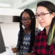 Two women working at a computer together